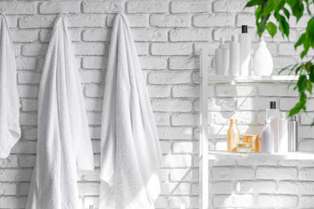 Cosmetic bottles against white bathroom wall background front viewの写真素材