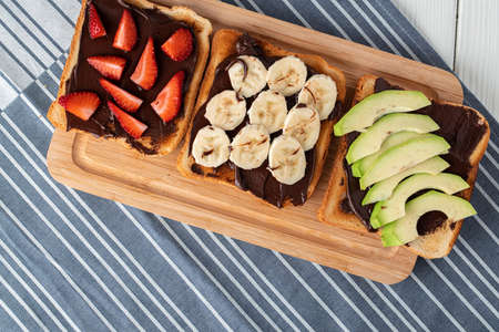 Assortment of sweet sandwiches with chocolate paste, peanut paste and fruit slicesの写真素材