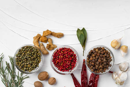 Red chili peppers and other spices on white textured background with copy space, top view