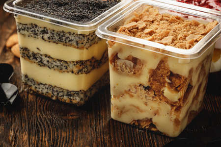 Creamy dessert in a plastic box on wooden tableの写真素材