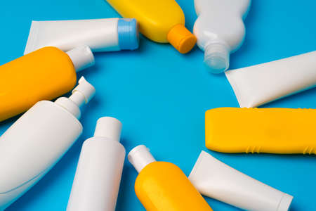 Bottles of sunscreen cream on blue background with copy spaceの写真素材