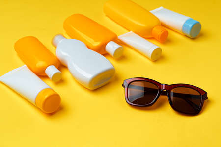 Sunglasses and sunblock cream close up on paper background with copy spaceの写真素材