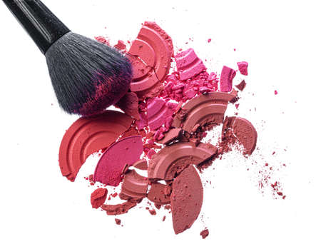 Crushed eyeshadows with brush isolated on white background. Close up.