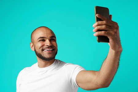 Young cheerful african american man taking selfie picture