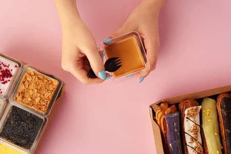 Female hands holding dessert in hands among fresh confectionary, close up