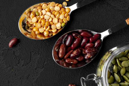 Red beans and pumpkin seeds on dark surface close upの写真素材