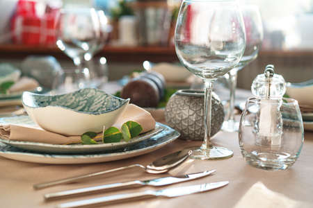 Beautiful elegant table setting with green stylish dishware and silver cutlery close up