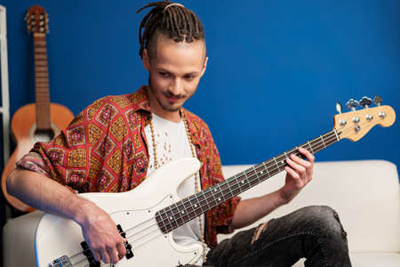 Young man guitar player sitting and performing