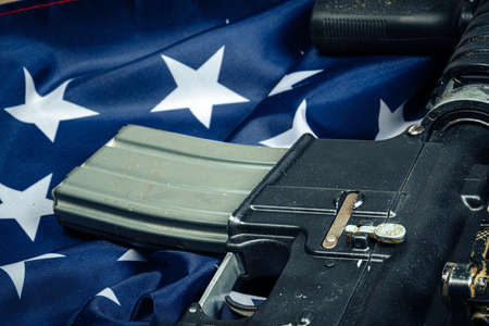 U.S. battle flag and assault rifle on the wooden table. Close up.の写真素材