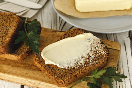 Buttered slice of rye bread on wooden table