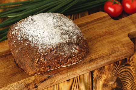 Rye bread on cutting board on wooden table