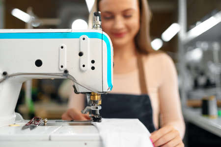 Portrait of seamstress working with sewing machineの写真素材