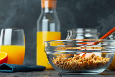 Bowl with crunchy granola on wooden table close up