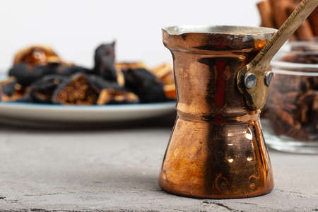 Copper turk with coffee and dried fruit pieces on table