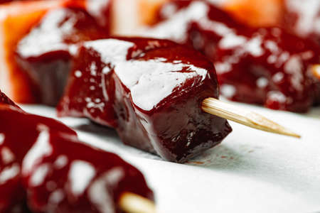 Raw liver kebab on skewers on wooden board