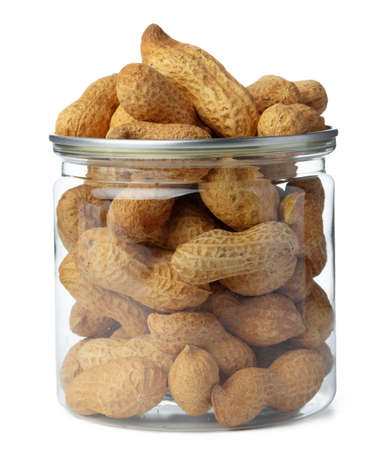 Glass jar with peanuts isolated on white
