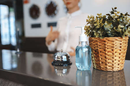 Hand sanitizer bottle on hotel reception deskの写真素材