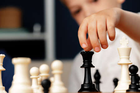 Close up photo of a little boy playing chessの写真素材
