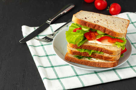 Healthy sandwich with vegetables on dark wooden background