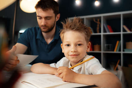 Dad and son doing school homework togetherの写真素材
