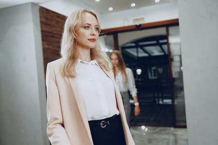 Two young women in formal clothes entering hotel lobbyの写真素材
