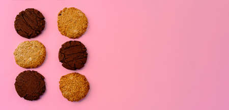 Chocolate cookies and oat cookies on pink background with copy spaceの写真素材