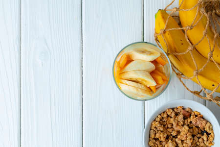 Tasty breakfast with granola, yoghurt and fruits in a glass bowlの写真素材