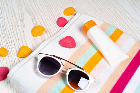 Beach accessories with sea shells on wooden background