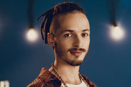 Close-up portrait of a young stylish man with dreadlocks