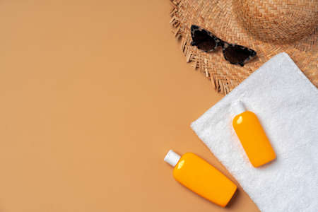 Suntan cosmetic product with towel, hat and sunglasses