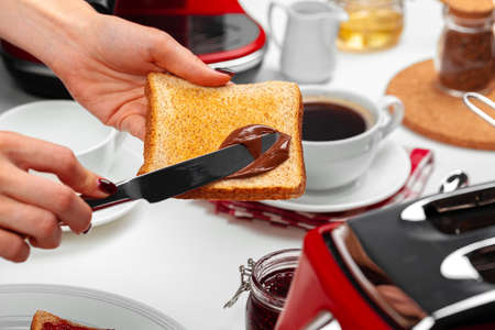 Female hand cooking toast with chocolate paste