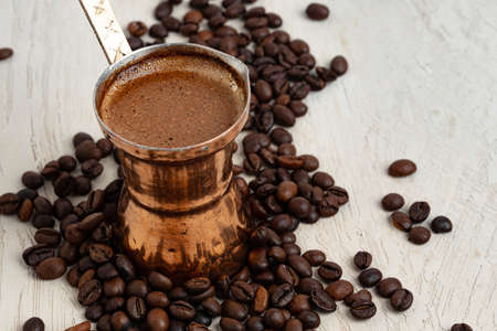 Close up of copper coffee turk on light textured surfaceの写真素材