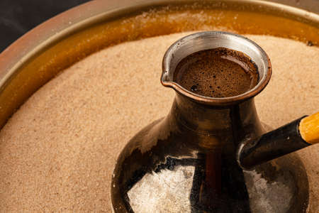 Copper turk with coffee brewing in sandの写真素材