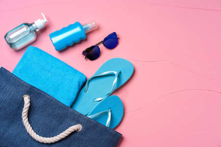 Beach essentials and blue beach bag on pink backgroundの写真素材
