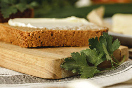 Buttered slice of rye bread on wooden table