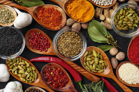 Background of variety of different vivid spices in wooden spoonsの写真素材