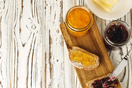 Slice of bread covered with fruit jam on wooden boardの写真素材