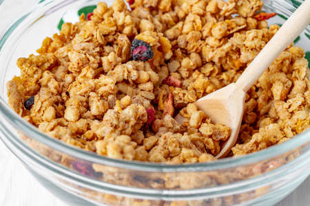 Bowl with granola on wooden table close up