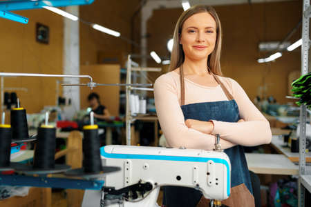 Portrait of a seamstress standing at working place and looking at camera