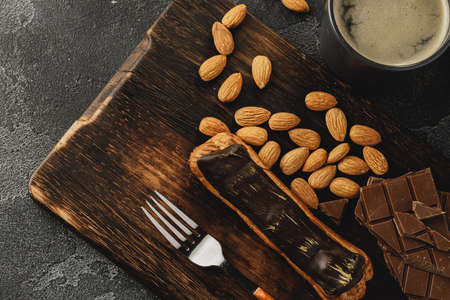 Eclair cake on dark wooden board on black table