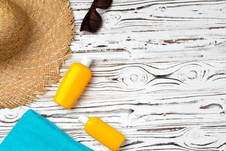 Straw hat, sunglasses and sunscreen bottle on wooden backgroundの写真素材