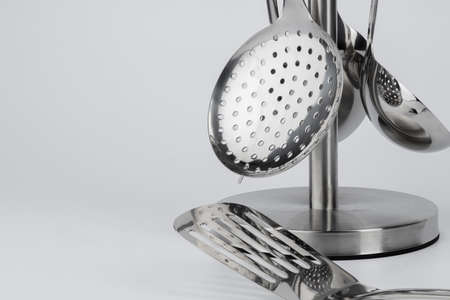 Aluminum holder with set of kitchen utensils on white background