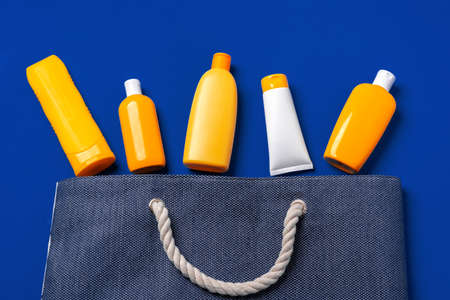 Bright yellow bottles of sunscreen product on dark blue paper backgroundの写真素材
