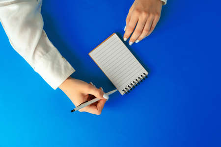 To do list. Top view of female hands writing in notebookの写真素材