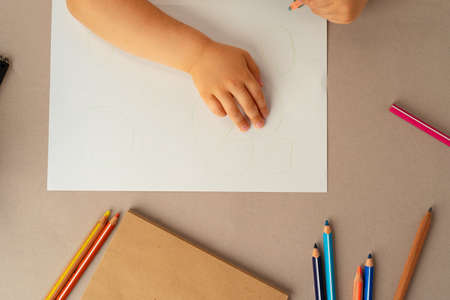 Kids hands writing in open notebook, top view, copy spaceの写真素材