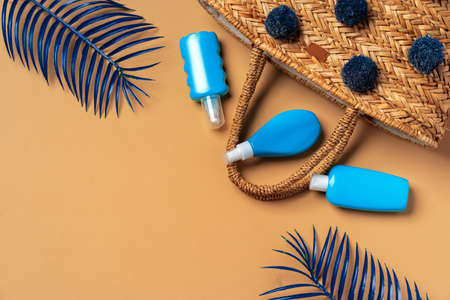 Blue cosmetic bottles on beige background with blue tropical palm leavesの写真素材