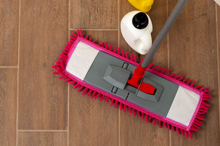 Top view of a pink mop on wooden floor