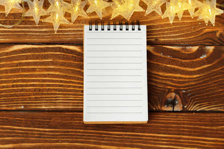 Blank sheet of paper with golden decorative stars. New year resolutions concept