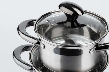 Set of new metal saucepans isolated on white
