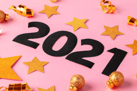 Concept of the year 2021. Golden stars with 2021 numbers on paper background